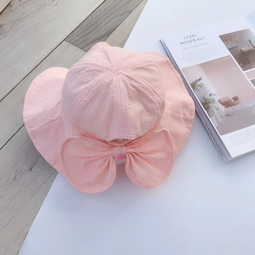 Adorable pink princess baby bucket hat with bow detail for sun protection and fashionable wear