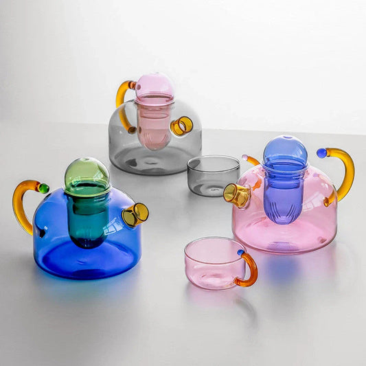 Elegant glass teapot and teacup set in vibrant contrasting colours, designed for a refined tea experience