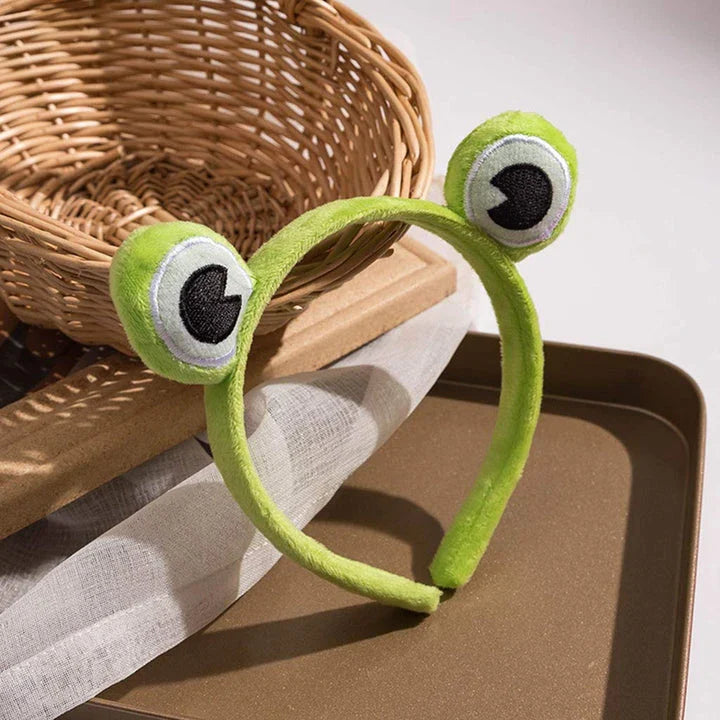 Charming frog-themed headband with plush coral fleece material and elastic band for a comfortable, customized fit