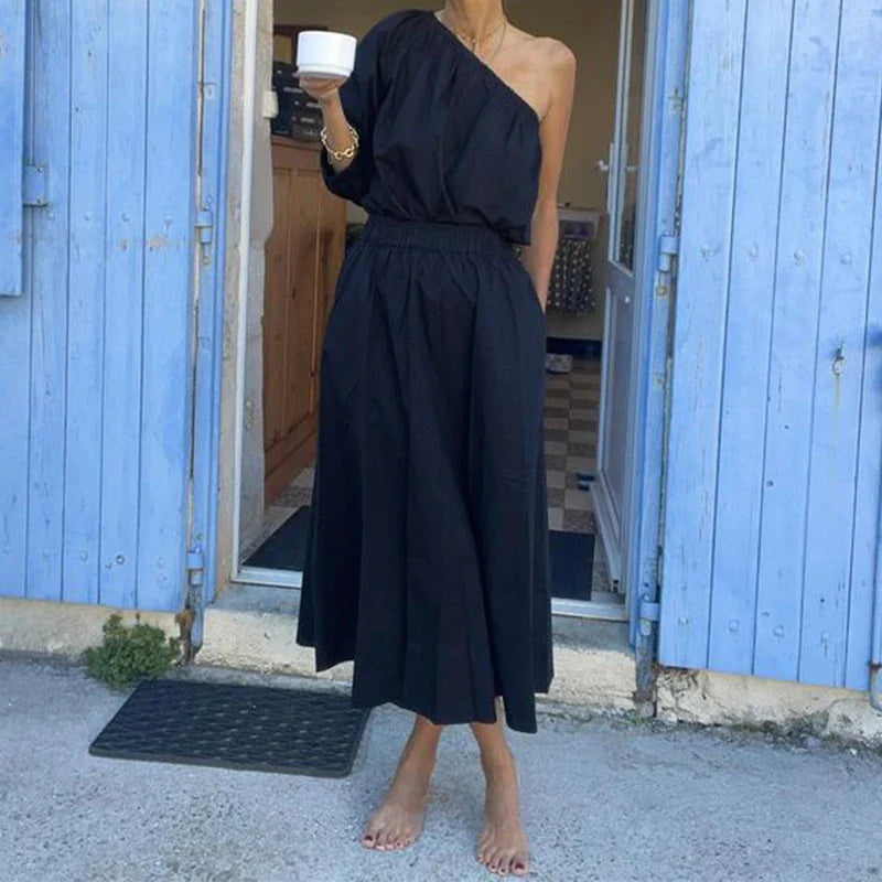 Elegant two-piece set with oblique shoulder blouse and midi skirt in black colour