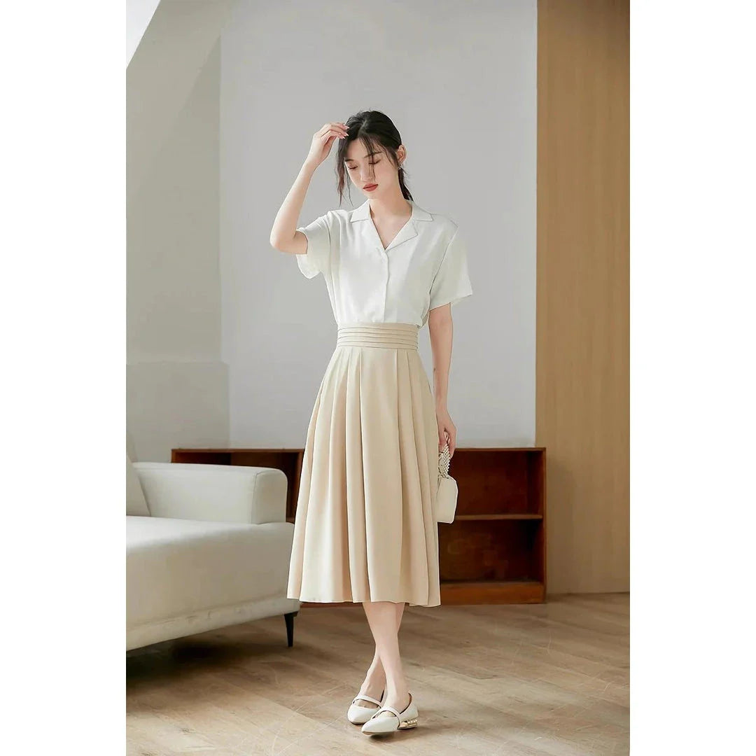 Elegant high-waisted pleated skirt with pockets in apricot colour, made from a blend of acrylic, cotton, and polyester for comfort and durability.