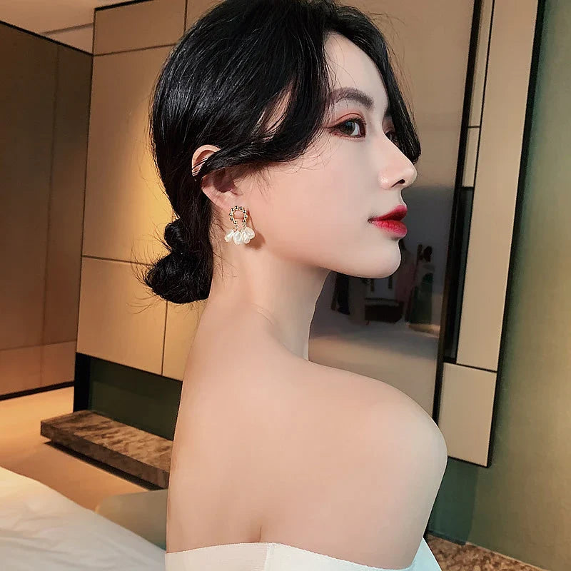 Pair of elegant Baroque-inspired pearl earrings with a silver and gold plated alloy setting