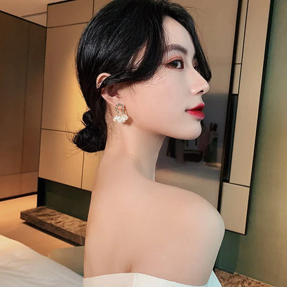 Pair of elegant Baroque-inspired pearl earrings with a silver and gold plated alloy setting