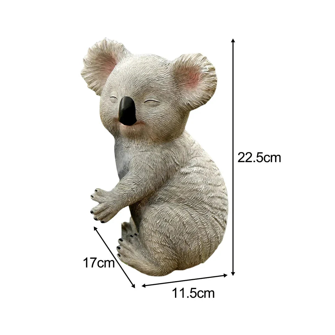A lifelike grey resin koala statue climbing on a tree, adding a charming and whimsical touch to a garden or outdoor space