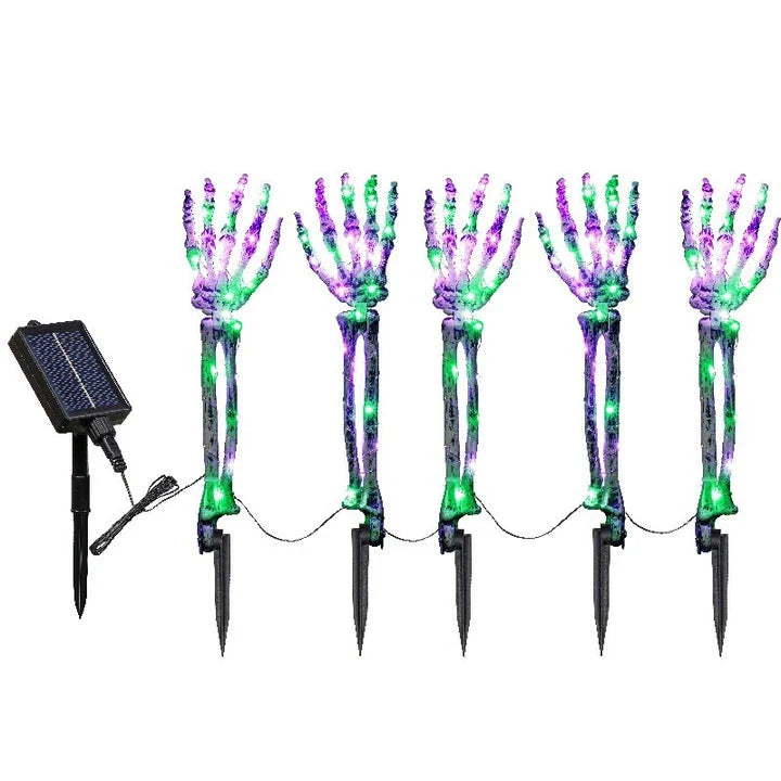 Solar-powered Halloween ground lamp with hand-shaped LED lights in purple and green colours, creating a spooky ambience in an outdoor courtyard