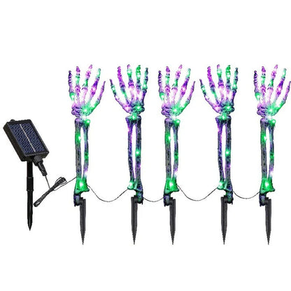 Solar-powered Halloween ground lamp with hand-shaped LED lights in purple and green colours, creating a spooky ambience in an outdoor courtyard